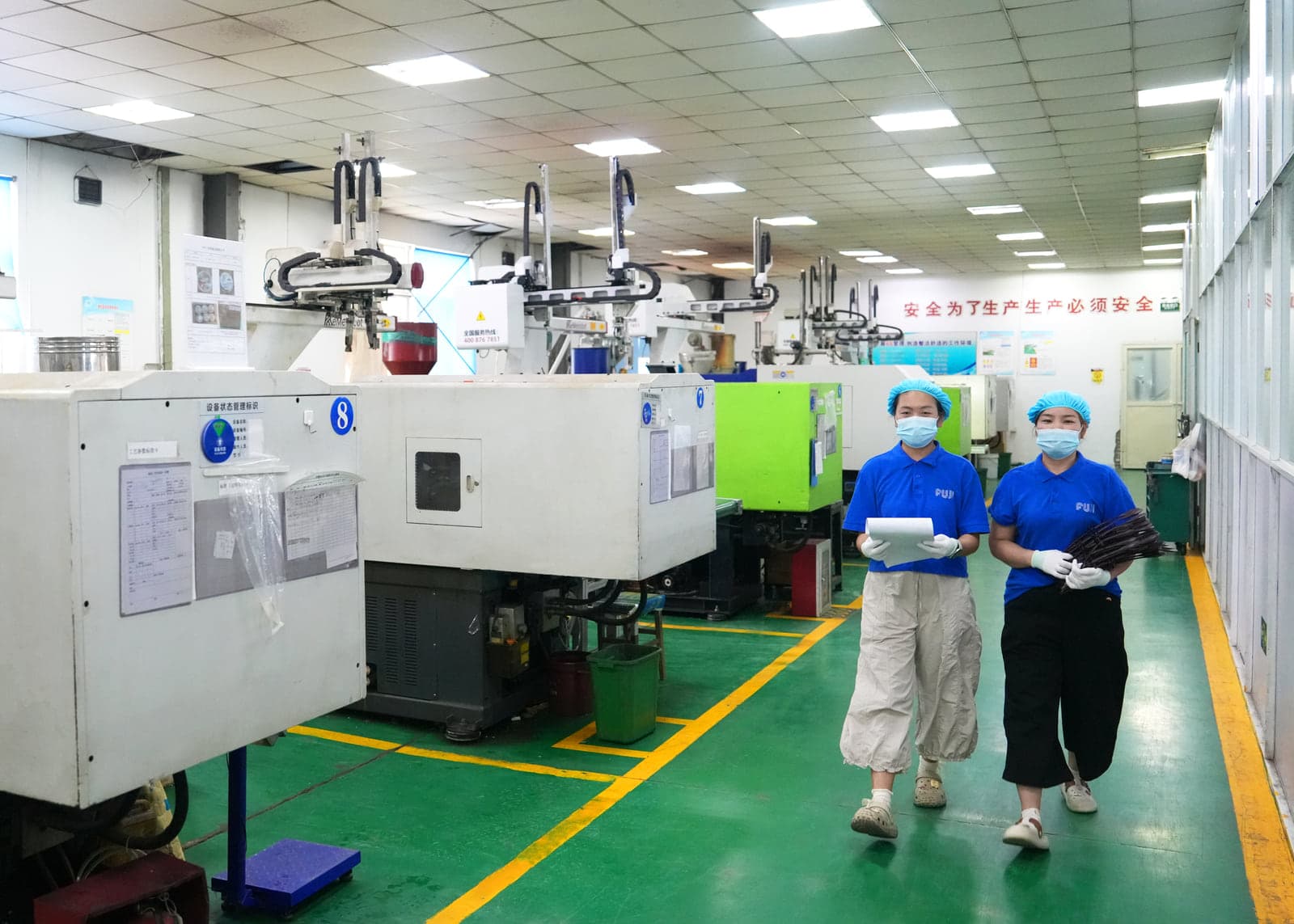 自社工場の生産設備と作業中のスタッフ